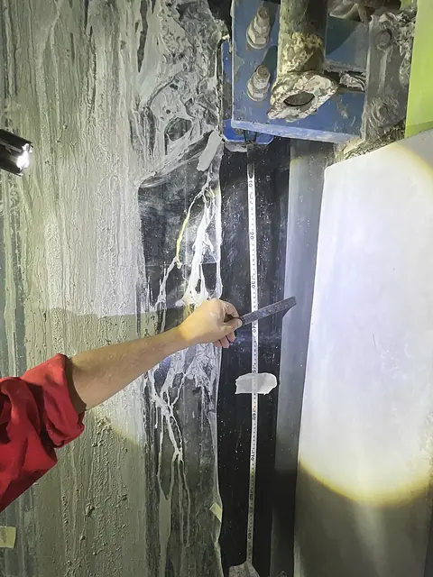 MAREX inspector measuring the gap at the edge of an acrylic panel with a steel rule and tape